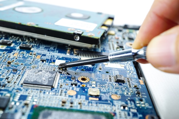 Technician repairing circuit of computer notebook by soldering iron