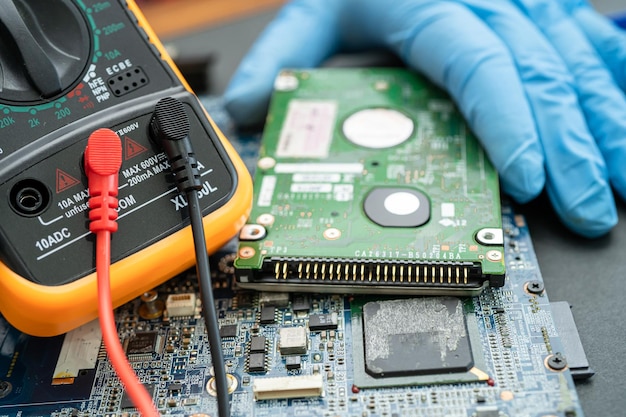 Technician repairing inside of hard disk by soldering iron.\
integrated circuit. the concept of data, hardware, technician and\
technology.