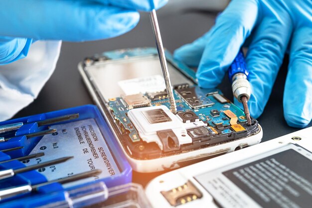 Technician repairing inside of mobile phone by soldering iron Integrated Circuit the concept of data hardware technology