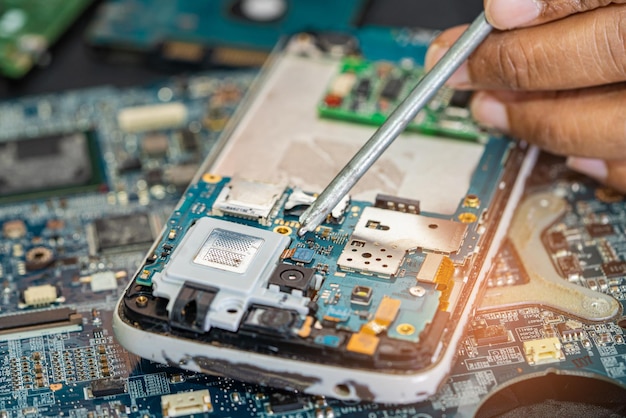 Technician repairing inside of mobile phone by soldering iron Integrated Circuit the concept of data hardware technology