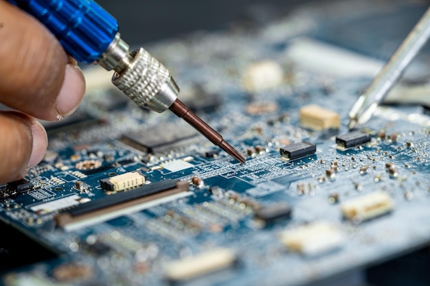 Technician repairing inside of mobile phone by soldering iron\
integrated circuit the concept of data hardware technology