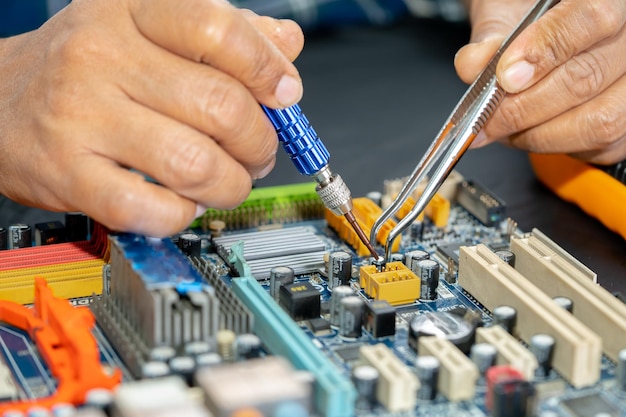 Technician repairing inside of mobile phone by soldering iron Integrated Circuit the concept of data hardware technology