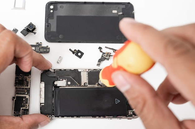 Technician repairing inside the smartphone motherboard with tools for recovery