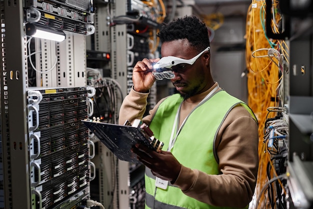 Technician repairing servers in data center and inspecting computer parts