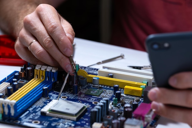 Foto un tecnico ripara una scheda madre in un centro servizi riparazione computer