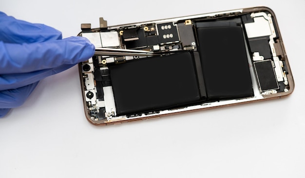 Photo technician replaces the battery of a cell phone or smartphone.