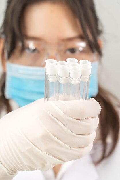 Technician scientist analyzing holding test tube in laboratory for testing it on COVID, COVID-19, coronavirus virus analysis