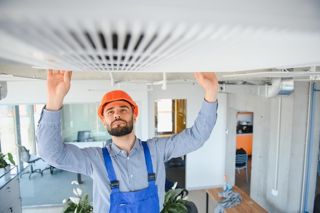 Technician service checking and repairing air conditioner indoors