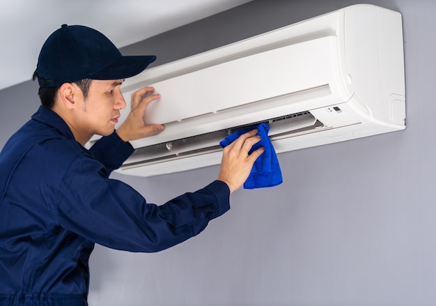 Technician service cleaning air conditioner with cloth