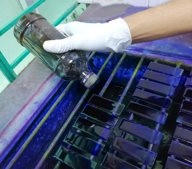 Technician staining glass slides of peripheral blood smear for microscopy