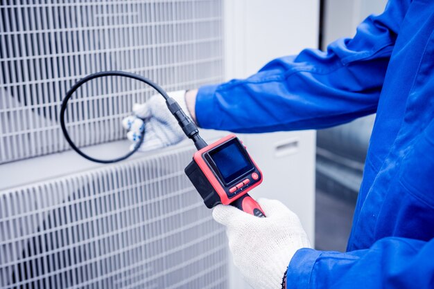 The technician uses a digital camera to check the clogging of the heat exchanger