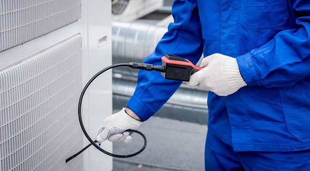 The technician uses a digital camera to check the clogging of the heat exchanger