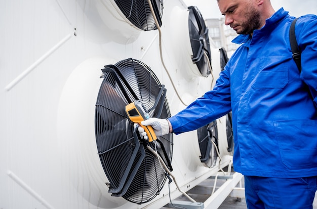 Technician uses a thermal imaging infrared thermometer to check the condensing unit heat exchanger