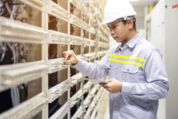 Technician using digital tablet in server room, repair card mainboard checking network link status