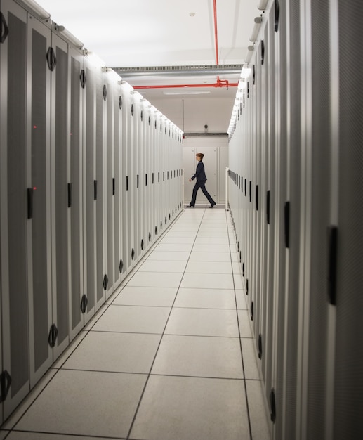 Foto tecnico che cammina nel corridoio del server