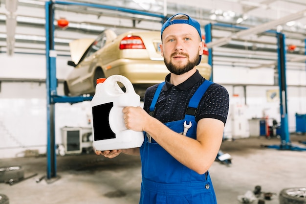 Photo technician with oilcan at garage