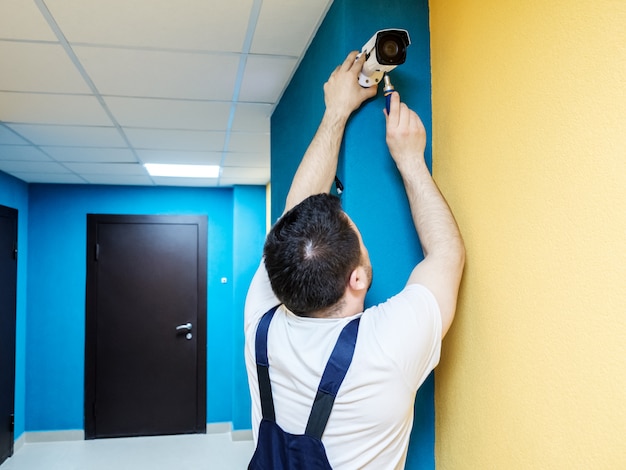 Technician worker installing video surveillance camera