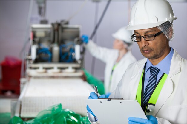 Technician writing on clipboard