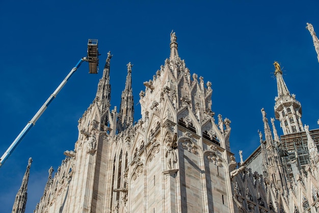 Technicians on lifting platform for scheduled maintenance plan\
and study of the degradation phenomena of the milan cathedral