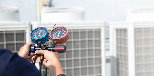 Foto technicus controleert airconditioner meetapparatuur voor het vullen van airconditioners service en onderhoud airconditioner