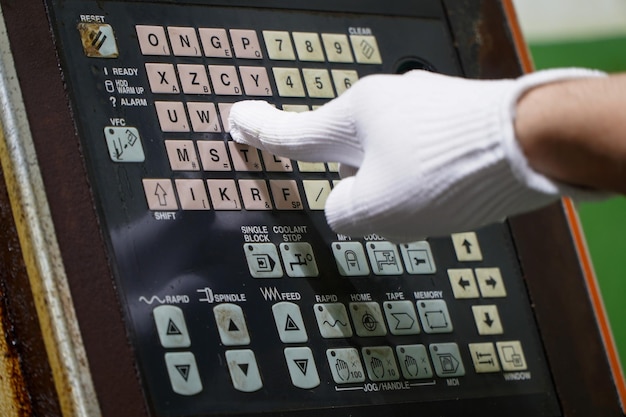 Foto technicus die het programma van een cnc-machine aanpastplastic- en metaalvormingsprocessen in de industrie