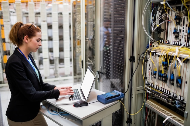 Technicus die laptop met behulp van terwijl het analyseren van server