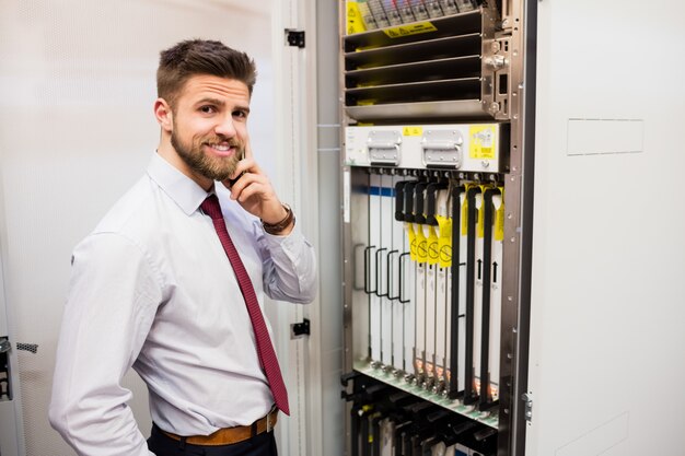 Technicus die op mobiele telefoon in serverruimte spreekt