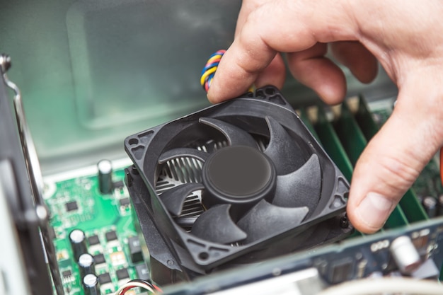 Technicus handen installeren cpu koeler fan op een computer pc moederbord