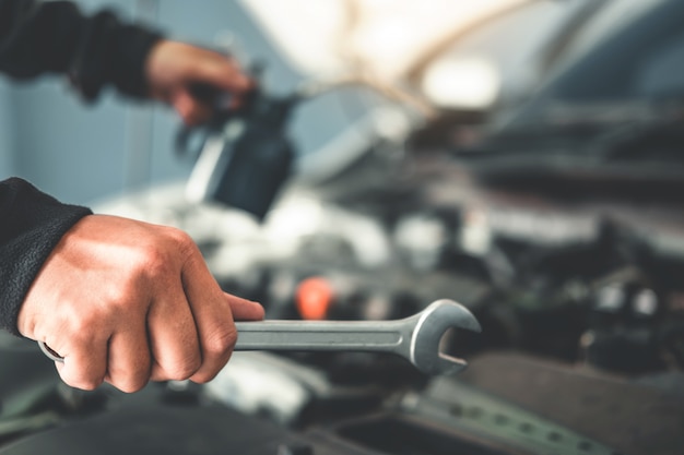 Foto technicus handen van automonteur die in autoreparatie werkt