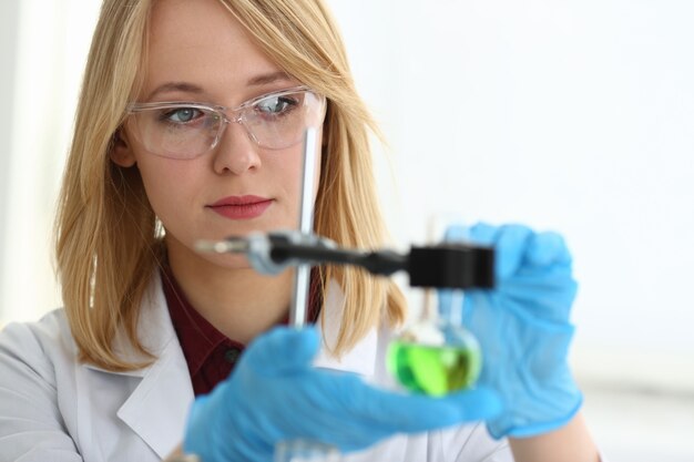 Technicus houdt in de armen in beschermende handschoenen monsterfles met gifvloeistof portret