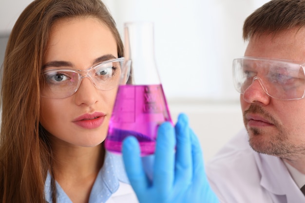 Foto technicus houdt in wapens in de fles van de beschermende handschoenensteekproef