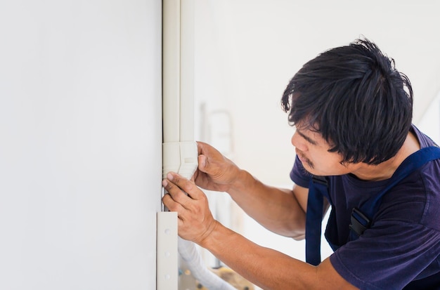 Technicus man die airconditioning installeert in het huis van een klant Reparateur die airconditionereenheid repareert Onderhouds- en reparatieconcepten