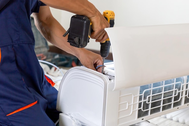 Technicus man die airconditioning installeert in het huis van een klant Reparateur die de airconditioner unit repareert Onderhouds- en reparatieconcepten