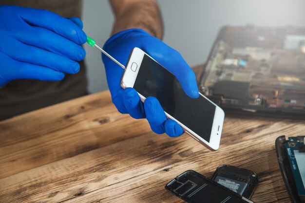 Technicus reparatie van mobiele telefoon aan tafel