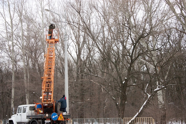 Technicus werkt in een emmer hoog op een hoogspanningsmast