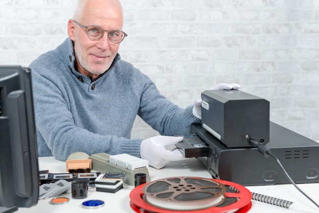 Technicusmens met vhs-cassette voor digitalisering