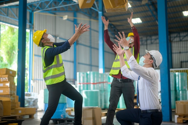 Technische mensen dragen gezichtsmasker gelukkig in moderne fabriek, industrieel succesvol en teamwerkconcept