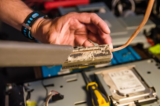 Technische ondersteuningsmedewerker stofzuigt processorradiator van stof