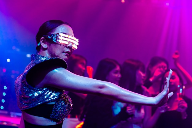 Techno-danseres in nachtclub dansen op het ritme van muziek van DJ