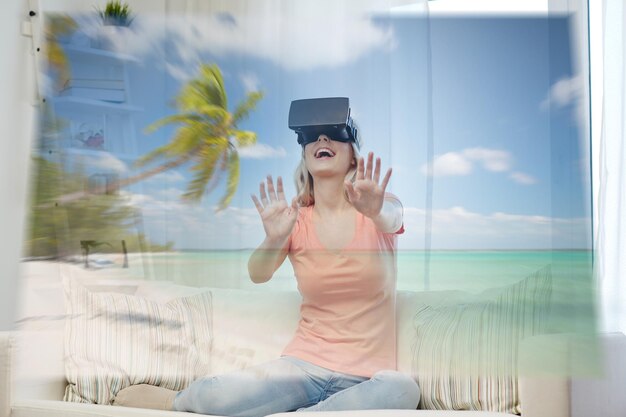 technologie, augmented reality, cyberspace, entertainment en people concept - gelukkige jonge vrouw met virtuele headset of 3D-bril met exotische tropische strandprojectie thuis