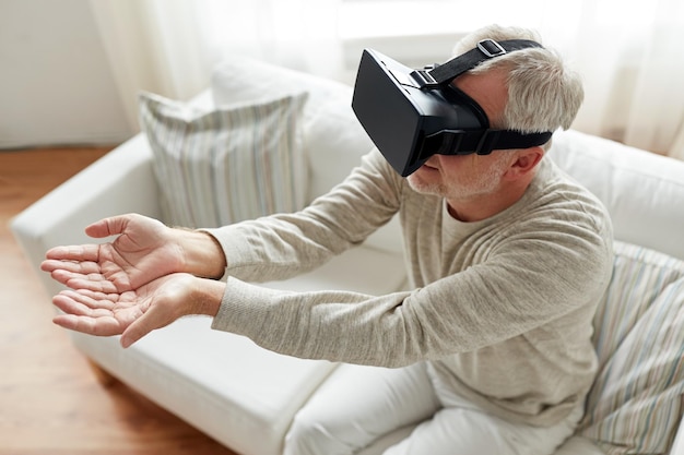 technologie, augmented reality, gaming, entertainment en people concept - senior man met virtuele headset of 3D-bril die thuis videogame speelt