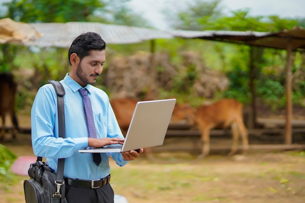 Technologie concept: jonge Indiase agronoom of bankier met behulp van laptop.