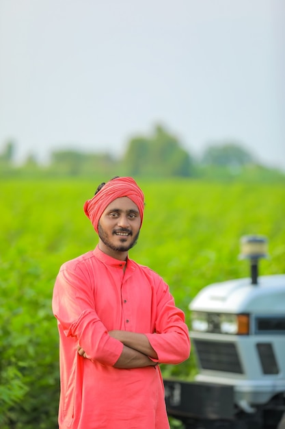 Technologie en mensen concept, portret van jonge Indiase boer met tractor