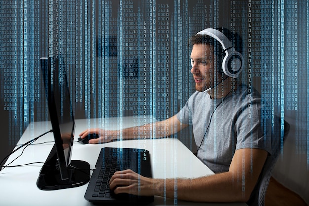 technologie, gaming, entertainment, laten we spelen en mensenconcept - gelukkige jonge man in headset met pc-computer die thuis een game speelt en playthrough of walkthrough-video streamt