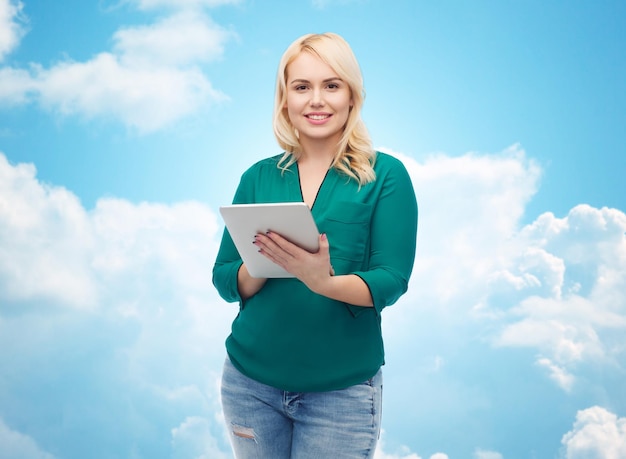 technologie, internet en mensen concept concept - lachende vrouw met tablet pc-computer over blauwe lucht en wolken achtergrond