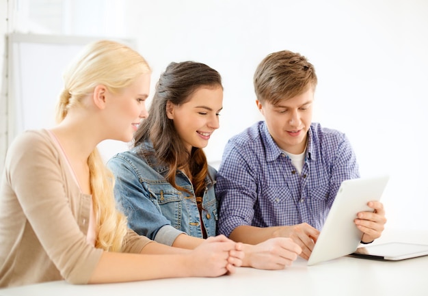 technologie, internet, school en onderwijsconcept - groep glimlachende tienerstudenten met tablet-pc-computers op school