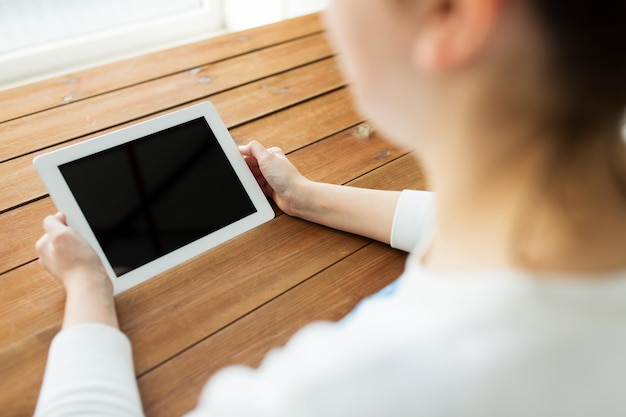 technologie, mensen en advertentieconcept - close-up van een vrouw met een leeg tablet pc-computerscherm op houten tafel