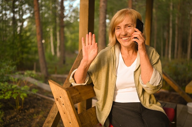 Technologie ouderdom mensen concept ouderen senior oude gelukkig lachende vrouw spreekt mobiele smartphone