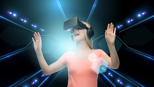 technologie, virtual reality, cyberspace en mensenconcept - gelukkige jonge vrouw met virtual reality-headset of 3D-bril op zwarte achtergrond en laserlicht