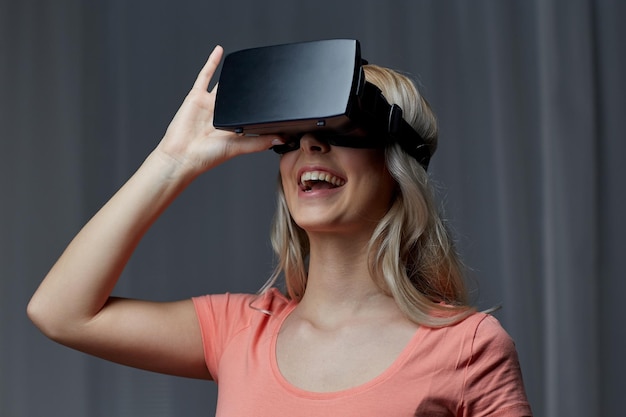 technologie, virtual reality, cyberspace, entertainment en mensenconcept - gelukkige jonge vrouw met virtual reality-headset of 3D-bril thuis